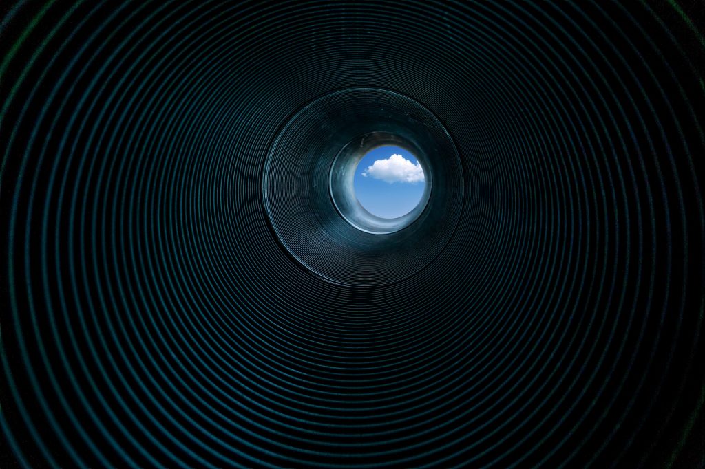 A spiral tube showing light at the end of the tunnel